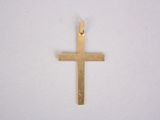 a close up of a gold cross on a white surface