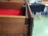 a wooden drawer with a red cloth inside of it