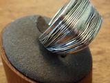 sterling silver ring on a wooden stand on a wooden surface