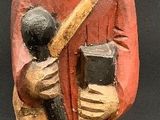 figurine of a man in a red robe holding a baseball bat and a ball
