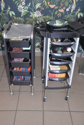two rolling carts with various items on them in a room