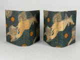 two pieces of paper with a horse on them on a white surface
