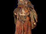statue of a woman holding a cat on a black background
