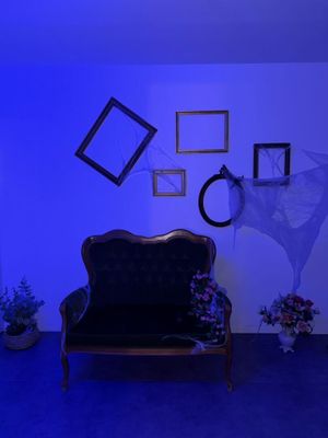un canapé dans une pièce baignée d'une lumière bleue, avec des tableaux accrochés au mur