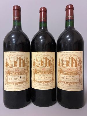 three bottles of red wine are lined up on a table