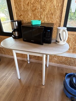 un micro-ondes et une cafetière posés sur une table dans une pièce