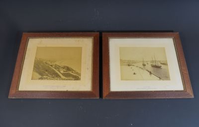two framed pictures of boats in a harbor on a blue wall
