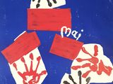 three handprints of people on a blue background with red and white paper