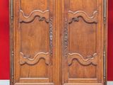 an old wooden armoire against a red wall in a room