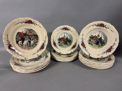four plates with a picture of a town on them on a table