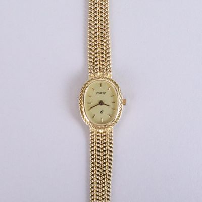 an image of a gold wrist watch with a chain around it
