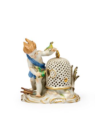 une figurine représentant un garçon avec un oiseau et une cage à oiseaux