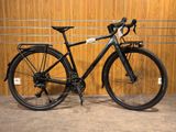 un vélo noir garé devant un mur en bois