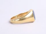 a close up of a gold ring with a blue stone