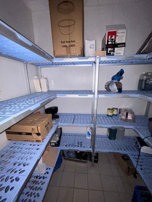 une étagère bleue au milieu d'une pièce remplie d'étagères