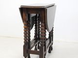 an old wooden table with a glass top and turned legs