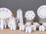 beaucoup d'assiettes et de tasses blanches et bleues sur la table