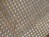 une grille métallique perforée posée sur un plancher en bois