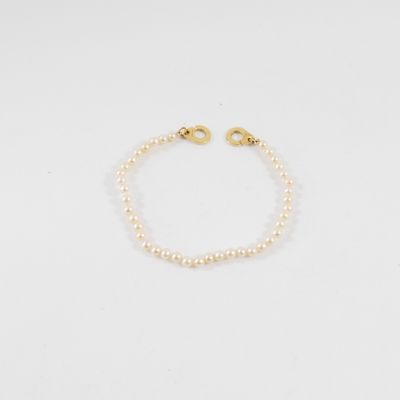 un bracelet de perles avec un fermoir en or sur fond blanc