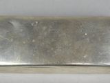 an old silver case with a skull on it on a white surface