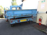 a blue truck that is parked next to a building