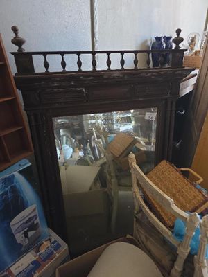 un miroir dans un coin d'une pièce, avec une chaise devant