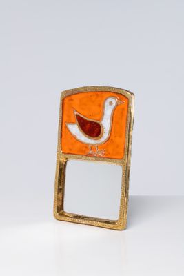 un petit miroir sur lequel est représenté un oiseau
