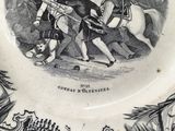 a black and white plate with a picture of a man on a horse