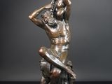 sculpture en bronze représentant une femme avec un oiseau sur la tête