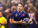 rugby player holding a ball in front of a crowd of people
