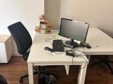 a white desk with a computer on it and a black chair