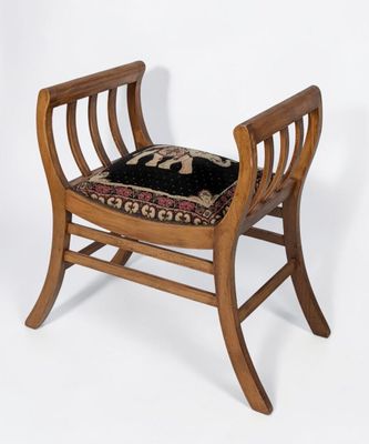 a small wooden chair with a black cushion on it