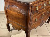 a small wooden chest of drawers on a tiled floor