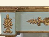 a mirror that has a gold decoration on the top of it