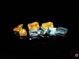 trois morceaux de verre jaune et bleu posés sur une surface noire