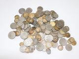 a pile of silver and gold coins on a white surface