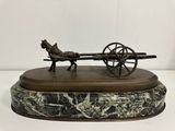 statue représentant un cheval tirant une charrette, posée sur un socle en marbre