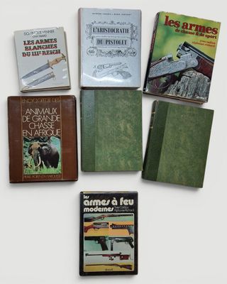Plusieurs livres sont disposés sur une surface blanche, devant un fond blanc.