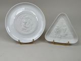 two white plates with a triangle shaped design and a triangle shaped plate with a picture of a man and woman on them
