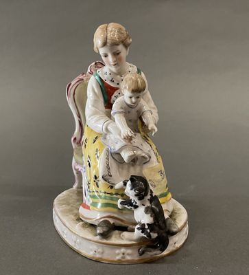 a figurine of a woman sitting on a chair with a dog