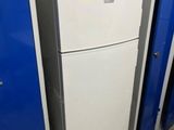 a white refrigerator in the middle of a room with blue cabinets