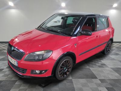 la petite voiture rouge est garée sur un sol en damier
