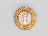 un gros plan sur une broche en or représentant le portrait d'une femme