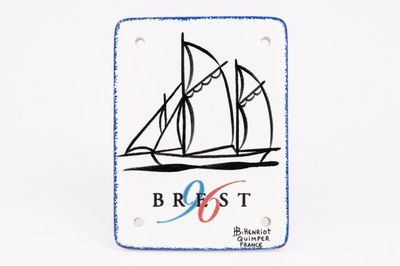white and blue ceramic plaque with a picture of a sailboat on it
