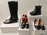 Plusieurs paires de chaussures pour femmes, noires et rouges, sont exposées.