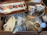a cardboard box full of dishes and cups and saucers