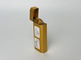 an image of a gold lighter with a white label on it