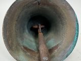 a metal bell with a wooden handle in the middle of it