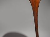an image of a wooden sculpture on a stand with a shadow