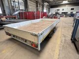 a flat bed trailer parked in a warehouse